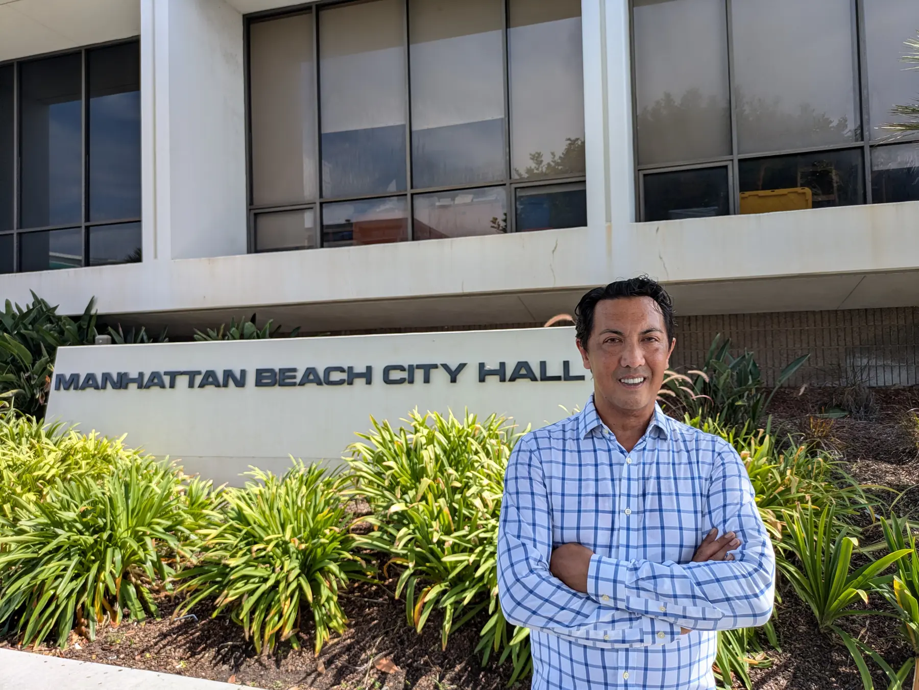 Joseph Ungoco standing outside Manhattan Beach City Hall with his arms folded